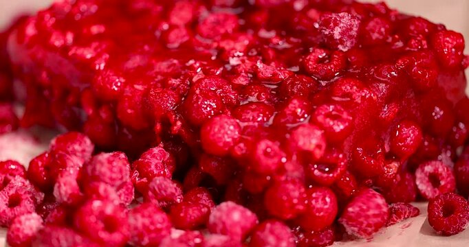 frozen red raspberries during their melting for dessert in winter close up