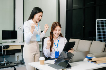 Obraz premium Two Asian businesswoman and man discuss investment project working and planning strategy with tablet laptop