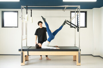 Japanese Woman Practicing Pilates on a Cadillac Machine