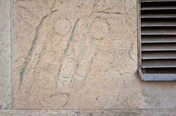 Limestone wall with fossilized shells of extinct straight-shelled cephalopods from the Ordovician period. A metal ventilation grate is partially visible on the side of the wall