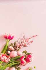 Pink tulips and Easter eggs on a pink background