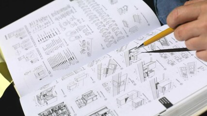 Close-up of an open architecture book displaying detailed floor plans and design schematics. The video captures technical drawings, spatial layouts, and construction diagrams, highlighting the plannin
