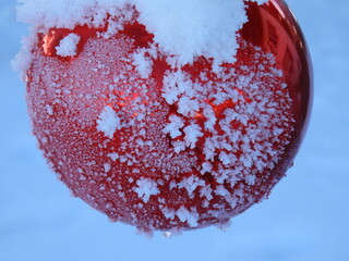 Eine gro&szlig;e, rote Weihnachtskugel in winterlicher Pracht