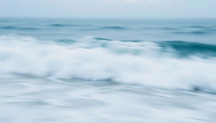 Fototapeta premium The blurred ocean waves gently crashing towards the shoreline softly