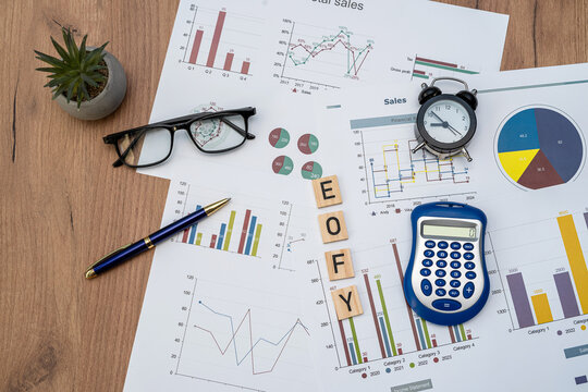 focus wooden blocks EOFY End of Financial Year with pen calculator and business diagraph paperwork