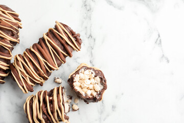 Delicious chocolate puffed rice bars on white marble table, flat lay. Space for text