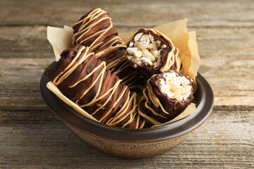 Delicious chocolate puffed rice bars on wooden table, closeup
