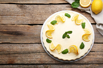 Delicious lemon cheesecake with mint and fresh fruits on wooden table, flat lay. Space for text