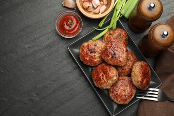 Delicious patties served on black table, flat lay. Space for text