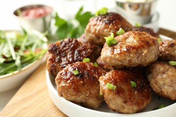 Delicious patties with green onions on table, closeup