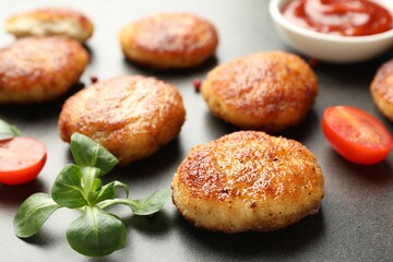 Tasty patties, spinach and tomato on grey textured table, closeup