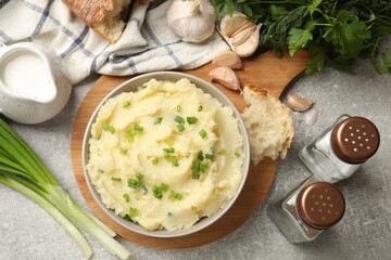 Delicious mashed potato with green onions served on grey table, flat lay