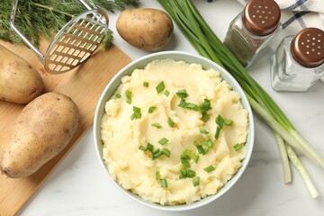 Delicious mashed potato with green onions served on white marble table, flat lay