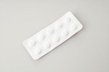 White Medicine Tablets in an Isolated Blister Pack on a Neutral Background