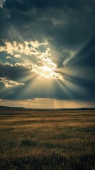 Serene Landscape with Dramatic Sky and Rays of Sunlight Breaking Through