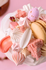 Traditional Ukrainian easter bread or sweet paska bread with topping decorated with cream and colorful meringue, macarons and eggs