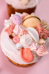 Traditional Ukrainian easter bread or sweet paska bread with topping decorated with cream and colorful meringue, macarons and eggs