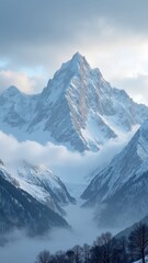 Fototapeta premium Mountain range covered in snow with a large peak in the background. The sky is cloudy and the mountains are covered in a thick layer of snow. The scene is serene