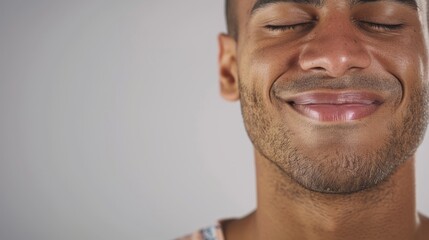 Fototapeta premium The image shows a man with closed eyes, smiling subtly.