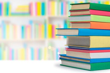 Books in multi-colored covers on an bookshelves. Literature for children. Collection in the library. Textbooks for school college or university
