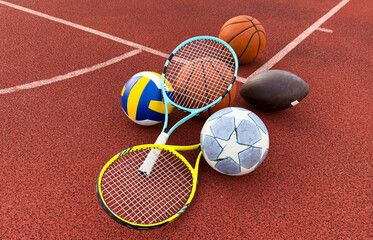 Sport games equipment - balls, rackets - on court.