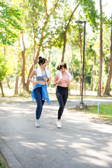 Obraz premium Happy woman, friends and running in park for workout, training or outdoor cardio exercise together. Active female person, athlete or runners smile for sports run, sprint or race in nature fitness