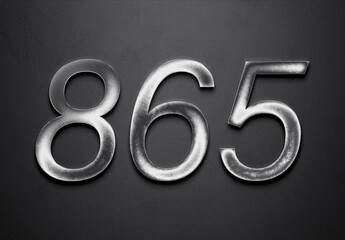 Chrome metal 3D number design of 865 on grey background.