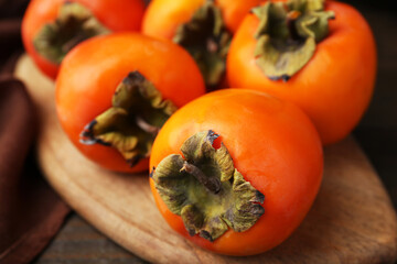 Delicious fresh juicy persimmons on wooden table, closeup