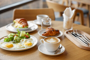Delicious breakfast served on wooden table in cafe