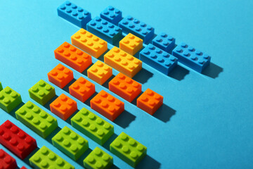 Construction toy. Colorful building bricks on light blue background, closeup