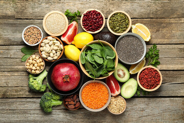 Different superfood products on wooden table, flat lay