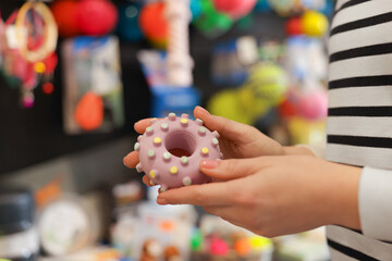 Woman with rubber toy in pet shop, closeup