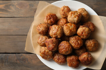 Many delicious meatballs on wooden table, top view. Space for text