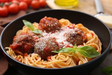 Delicious pasta with meatballs and cheese in bowl on table, closeup