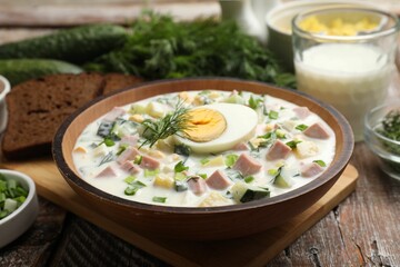 Delicious okroshka soup with kefir served on wooden table, closeup