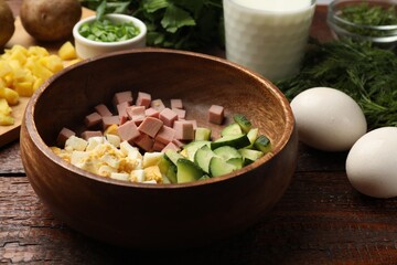 Different ingredients for okroshka soup on wooden table, closeup