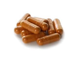 Many turmeric capsules isolated on white. Herbal dietary supplement