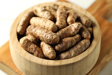 Raw tumeric rhizomes on white table, closeup