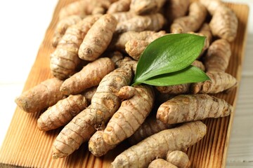 Raw tumeric rhizomes on white table, closeup