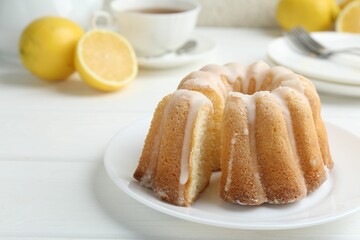 Delicious lemon cake with glaze on white wooden table, closeup