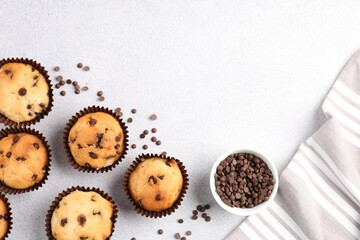 Delicious muffin with chocolate chips on light grey table, flat lay. Space for text