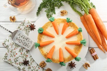 Delicious homemade carrot cake served on white wooden table, flat lay