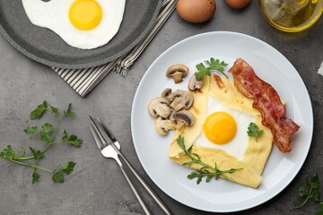 Delicious crepe bretonne with bacon, mushrooms and arugula served on grey table, flat lay