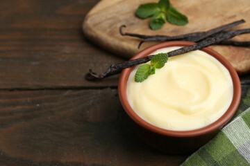 Tasty vanilla pudding, mint and pods on wooden table, closeup. Space for text