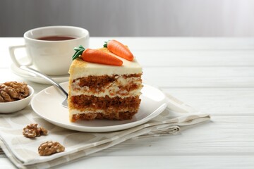 Piece of delicious homemade carrot cake served on white wooden table, space for text
