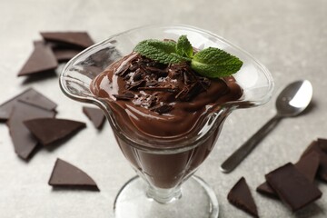 Delicious chocolate mousse in glass dessert bowl on grey table, closeup