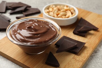 Delicious chocolate mousse in glass bowl and ingredients on grey table, closeup