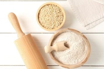 Brown rice and flour on white wooden table, flat lay