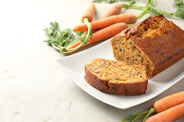 Homemade carrot cake with nuts and vegetables on light grey table, closeup. Space for text