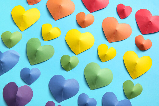 Colorful hearts made of paper on blue background. LGBT concept - Powered by Adobe